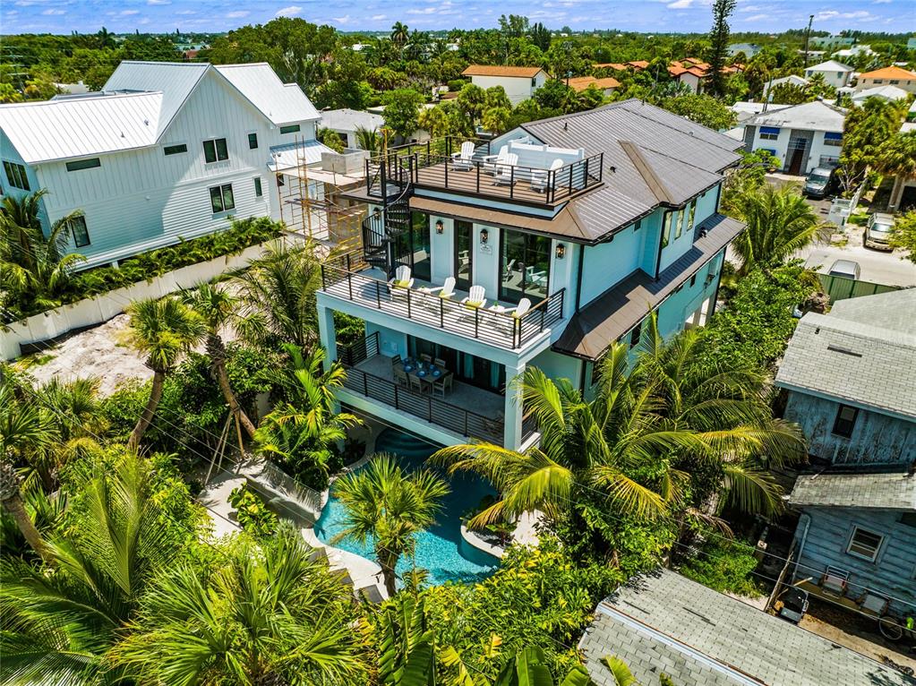 An aerial view of a multi-story house with balconies, a rooftop deck, and a pool — 209 GARFIELD DRIVE, SARASOTA, FL