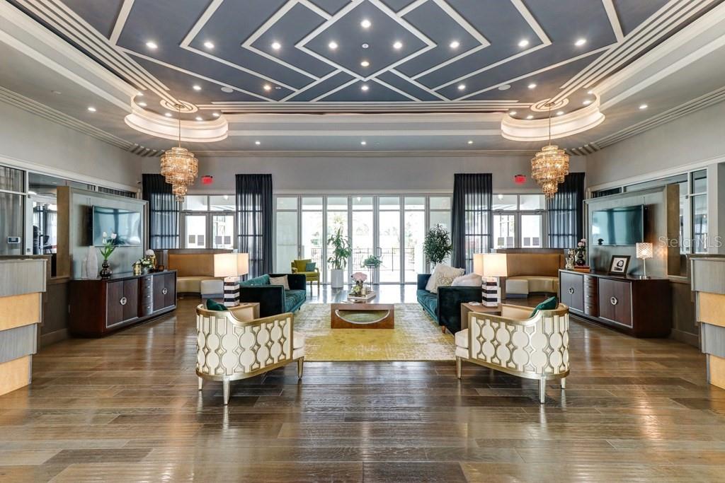 A symmetrical lobby features a geometric ceiling, two crystal chandeliers, and matching seating areas — 1688 CELEBRATION BOULEVARD UNIT The Sunset, CELEBRATION, FL
