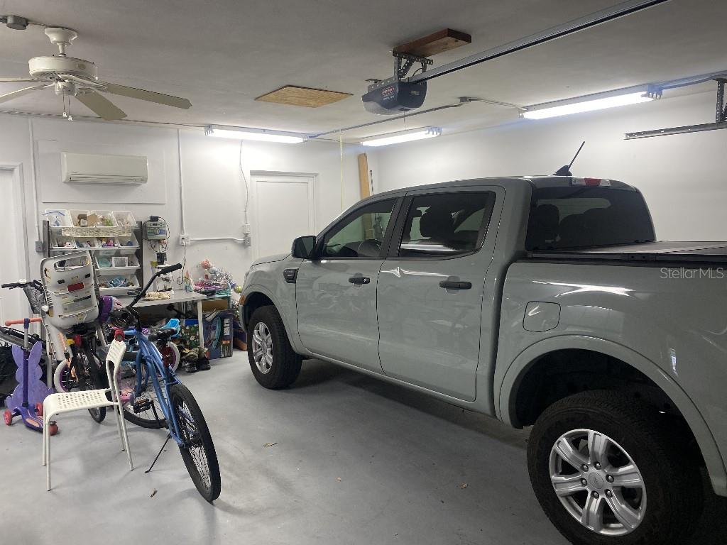 A gray pickup truck is parked inside a garage with white walls and bicycles — 307 ORANGEWOOD LANE, LARGO, FL