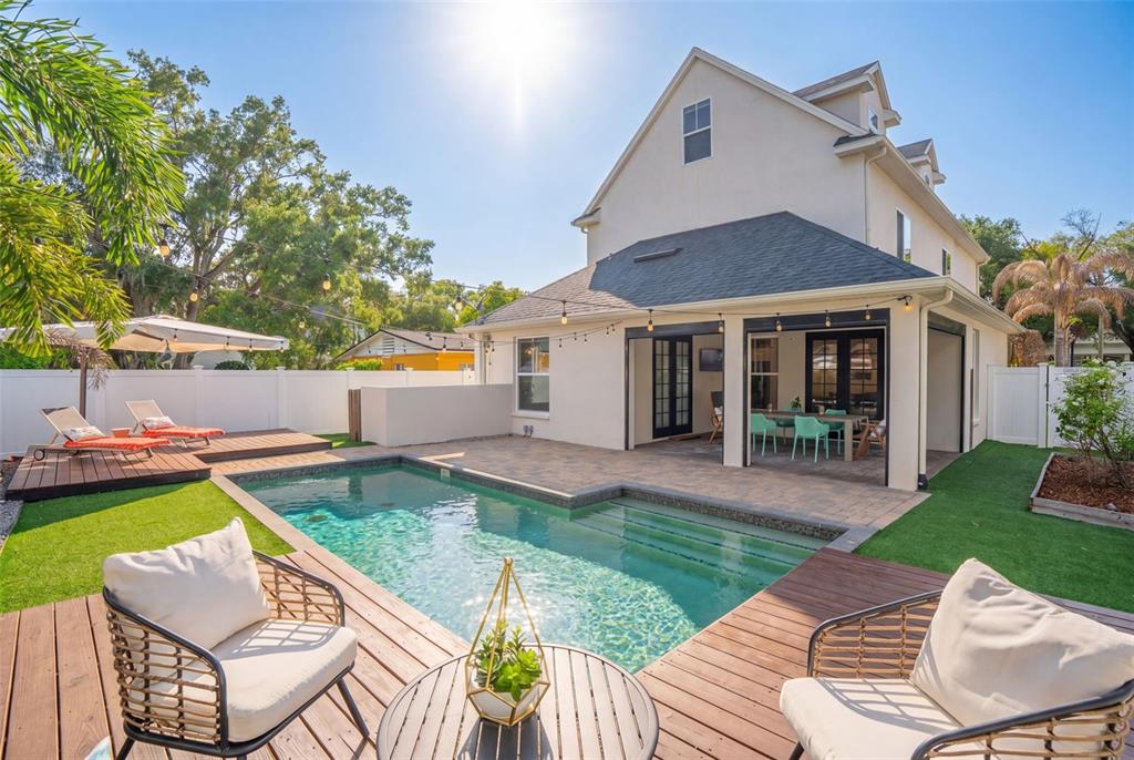 A backyard features a swimming pool, wooden decking, patio furniture, and a two-story house — 1420 MAGNOLIA AVENUE, WINTER PARK, FL