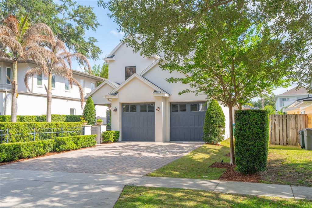 A two-story house with a two-car garage, a paved driveway, and manicured landscaping — 1420 MAGNOLIA AVENUE, WINTER PARK, FL