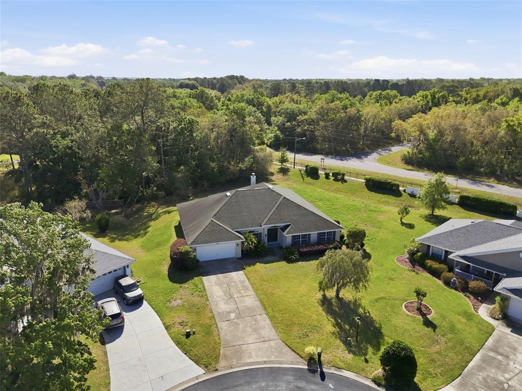 An aerial view shows a single-story house with a dark roof and a concrete driveway — 42 SUNRISE DRIVE, OCALA, FL