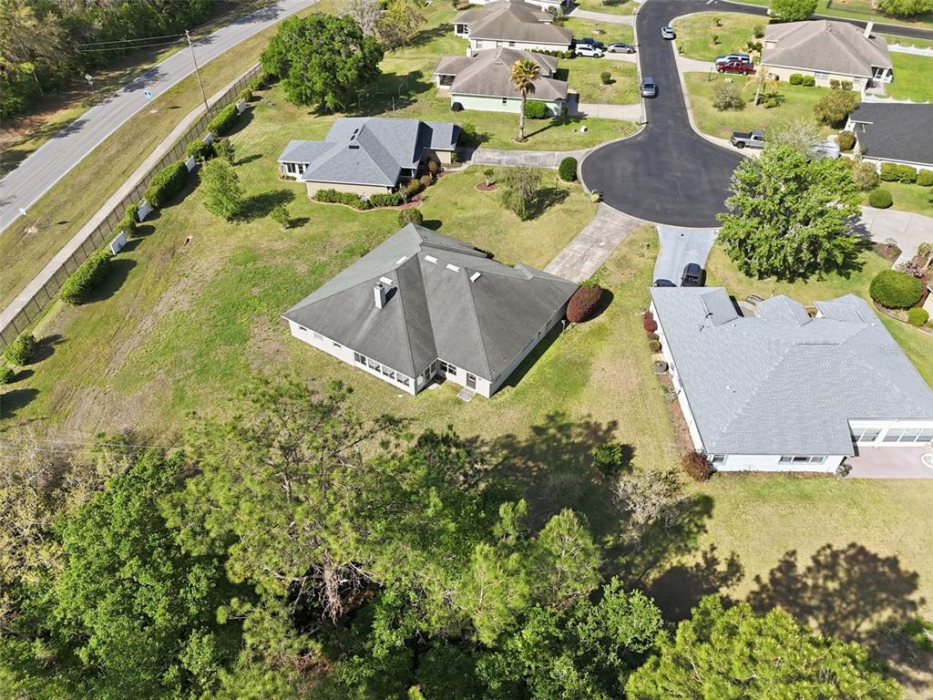 An aerial view shows several suburban houses with gray roofs situated on large grassy lots — 42 SUNRISE DRIVE, OCALA, FL