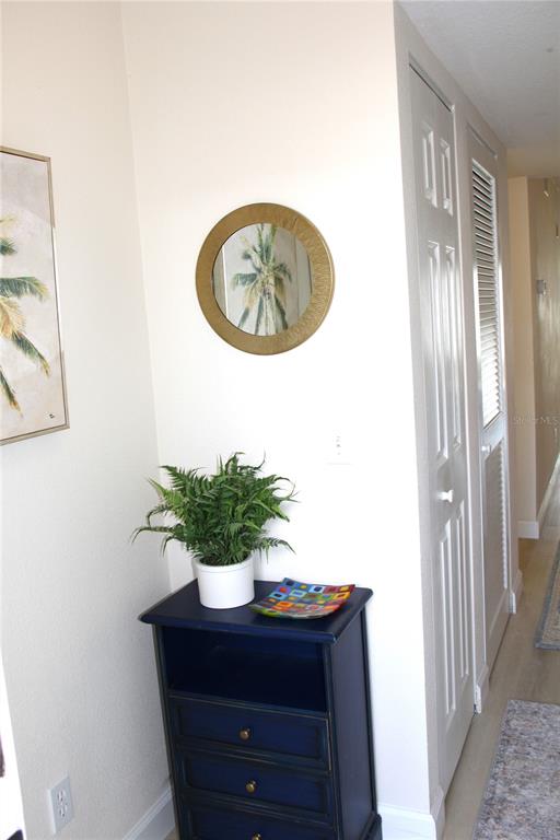 A sunroom with tile flooring and sliding glass doors overlooking a grassy lawn and pond — 204 SILVER LAKE DRIVE UNIT 102, VENICE, FL