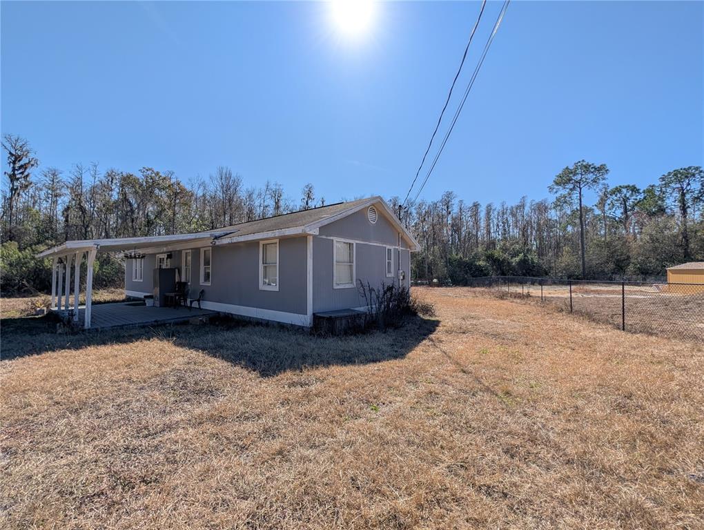 A gray single-story house with a covered porch sits on a dry, grassy lot — 342 CREEKWOOD RUN, LAKELAND, FL