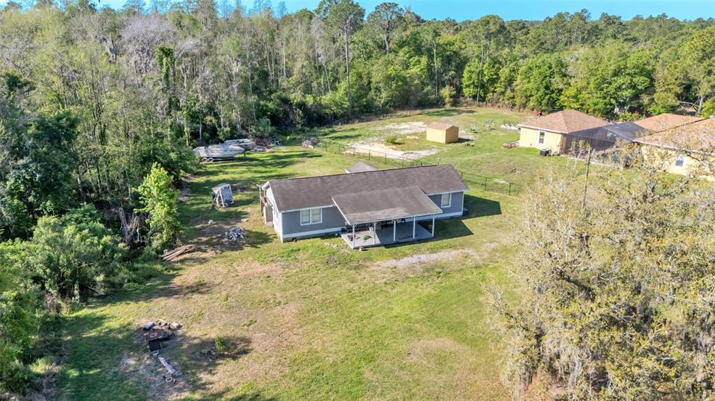 An aerial view shows a single-story house with a covered porch on a large lot — 342 CREEKWOOD RUN, LAKELAND, FL