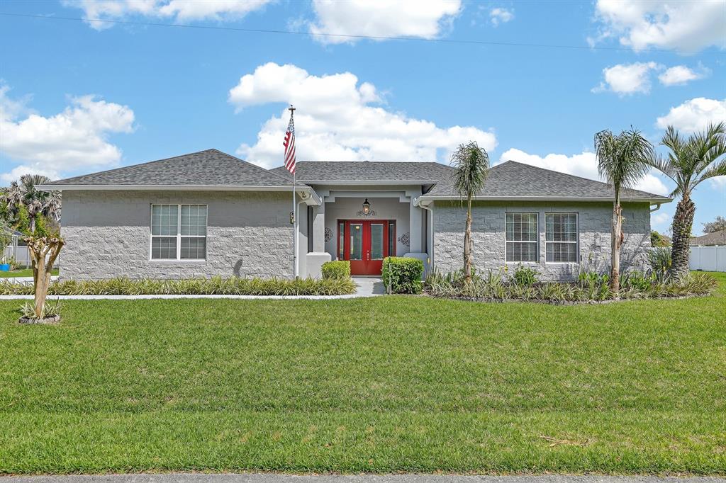 A single-story gray house with a red front door and an American flag — 50 FURNESS PLACE, PALM COAST, FL