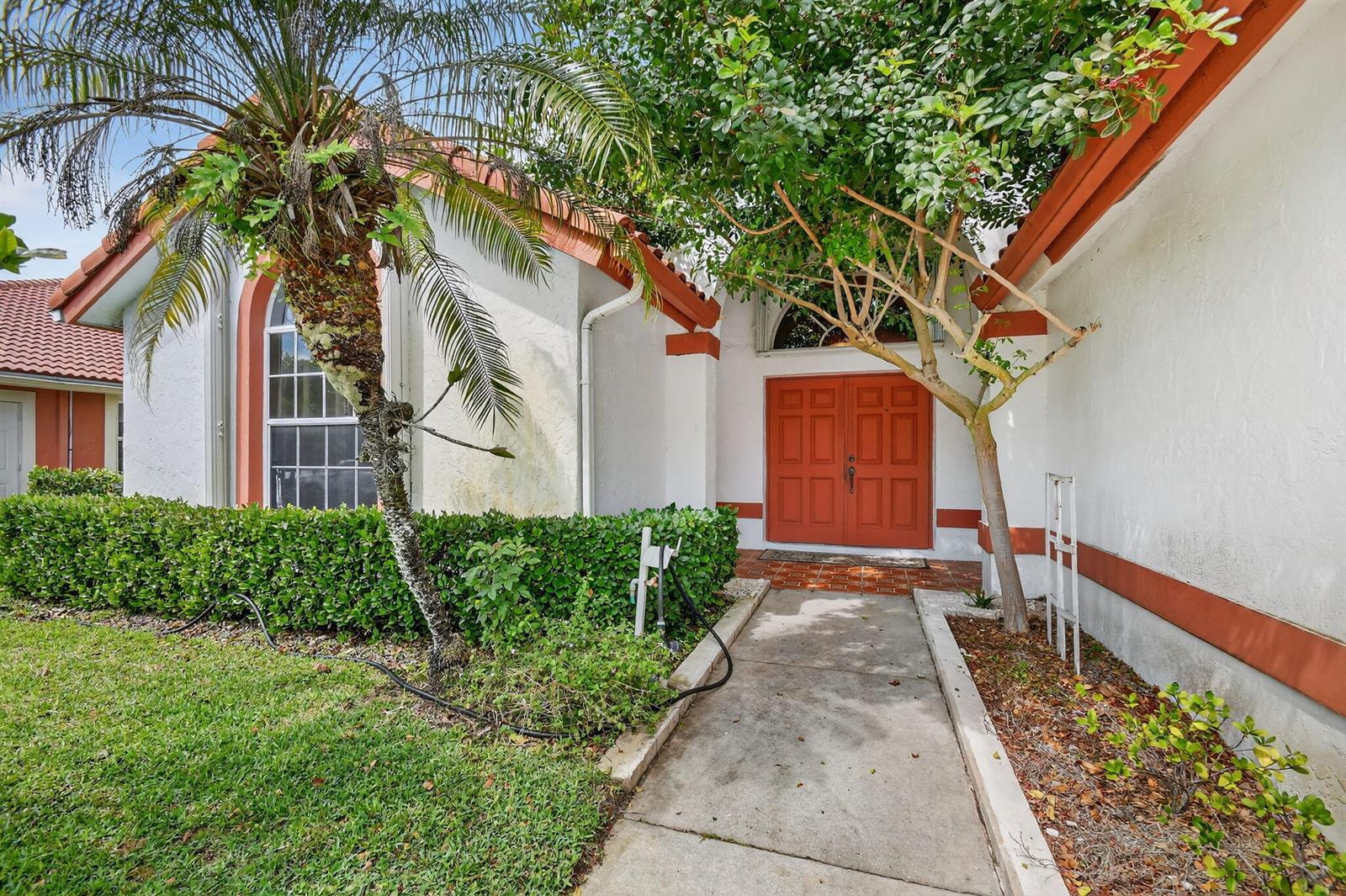 A single-story house with a white exterior, red tile roof, and a two-car garage — 2453 Stonegate Drive, Wellington FL 33414, WELLINGTON, FL