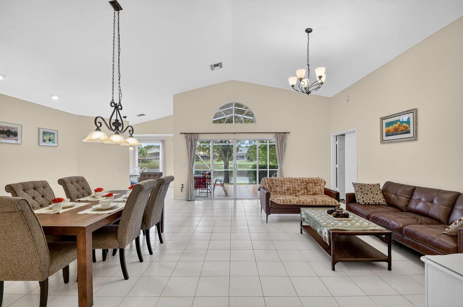 The exterior of a house features a concrete walkway leading to double orange front doors — 2453 Stonegate Drive, Wellington FL 33414, WELLINGTON, FL