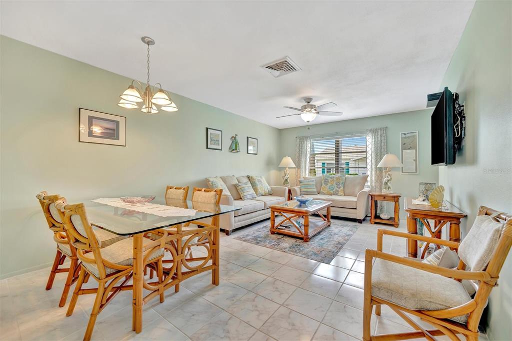 A lamp with a bird-shaped base sits on a table in a light-green entryway — 6057 CORAL WAY UNIT 3, BRADENTON, FL