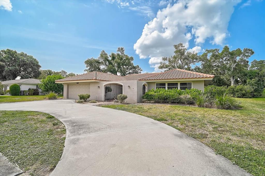 A single-story house with a tile roof, a two-car garage, and a curved concrete driveway — 426 WHITFIELD AVENUE, SARASOTA, FL