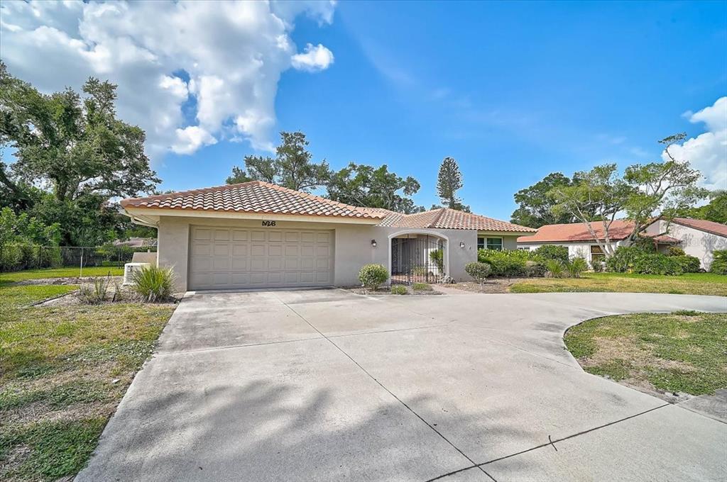 A single-story house with a tiled roof, a two-car garage, and a concrete driveway — 426 WHITFIELD AVENUE, SARASOTA, FL