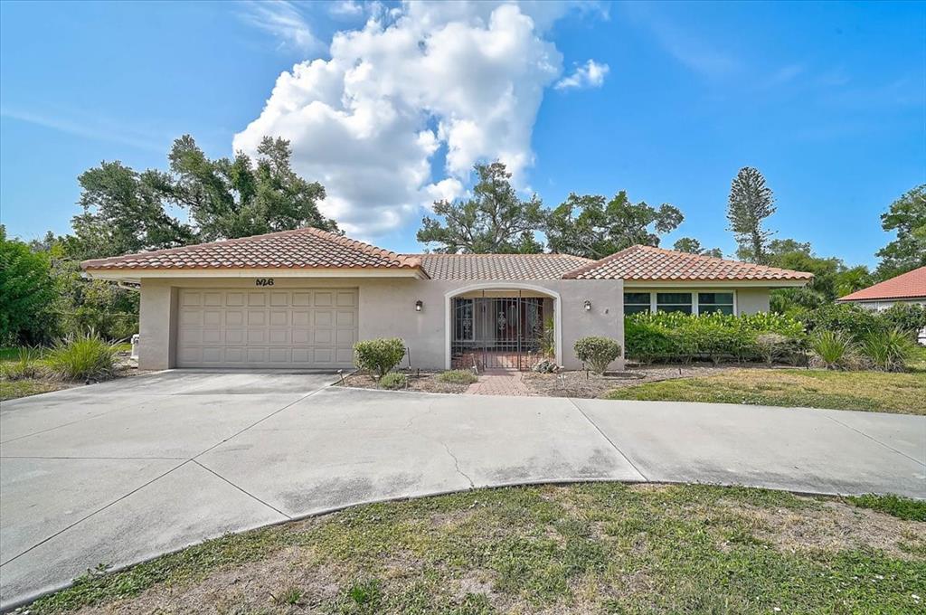 A single-story house with a tile roof, a two-car garage, and a gated entryway — 426 WHITFIELD AVENUE, SARASOTA, FL