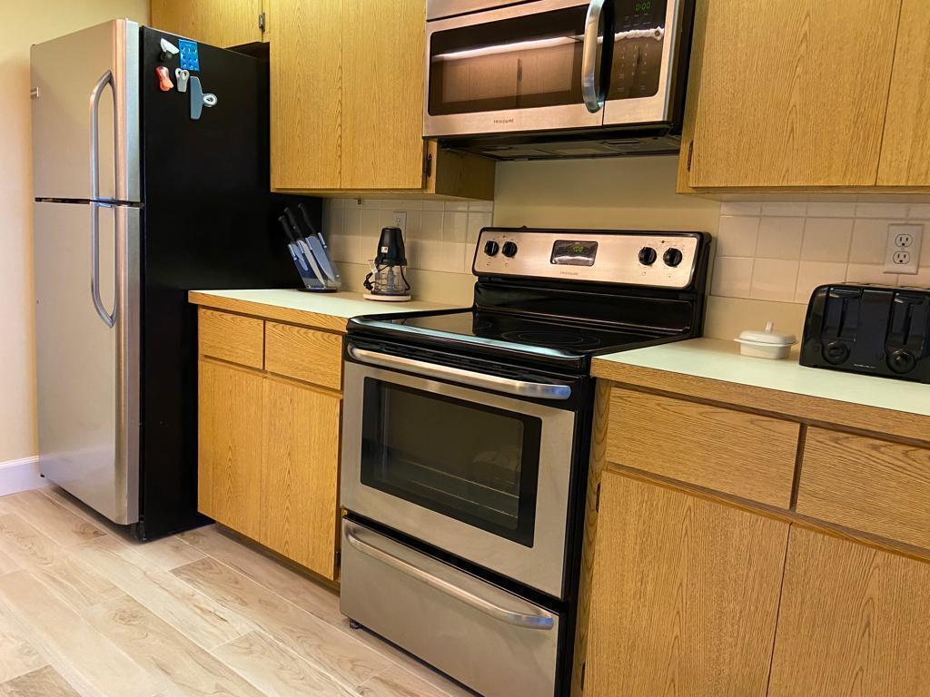 A kitchen features oak cabinets, stainless steel appliances, and light-colored countertops — 8010 80th Way, West Palm Beach FL 33407, WEST PALM BEACH, FL