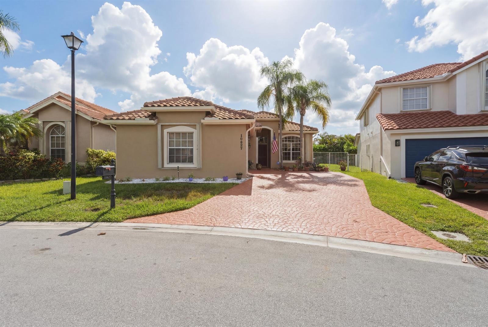 A single-story tan house with a red tile roof and a patterned driveway — 10827 La Salinas Circle, Boca Raton FL 33428, BOCA RATON, FL