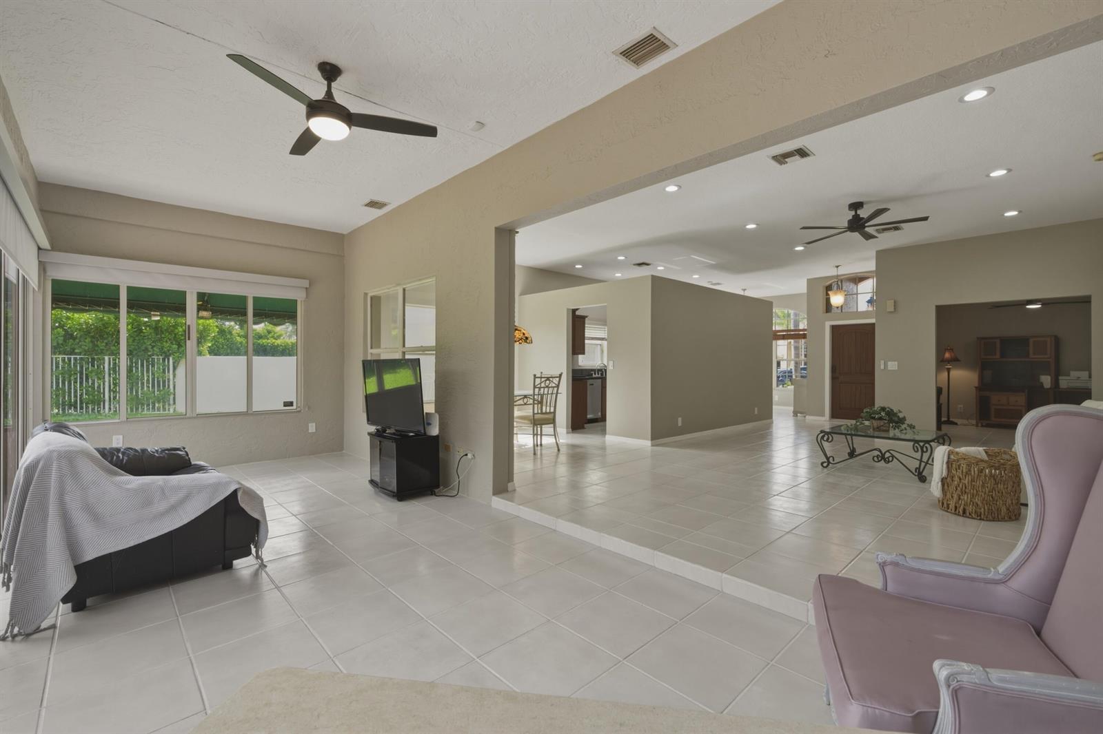 A spacious living area features light tile flooring, neutral walls, and a sunken seating space — 10827 La Salinas Circle, Boca Raton FL 33428, BOCA RATON, FL