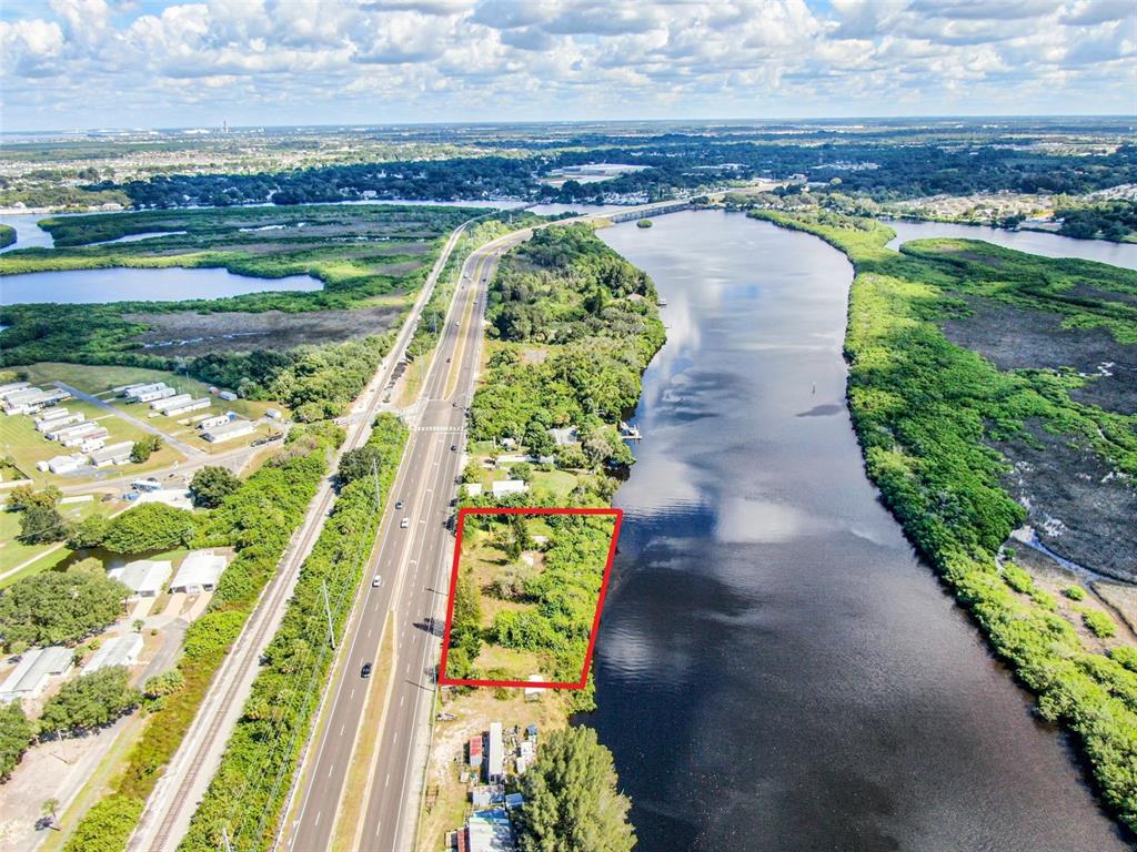 An aerial view shows a rectangular plot of land bordered by a highway and water — 2508 S US HIGHWAY 41, RUSKIN, FL