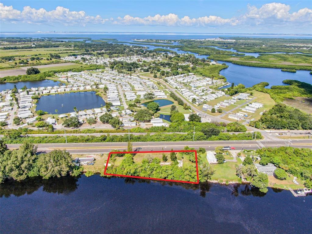 An aerial view shows a rectangular waterfront lot outlined in red next to a highway — 2508 S US HIGHWAY 41, RUSKIN, FL