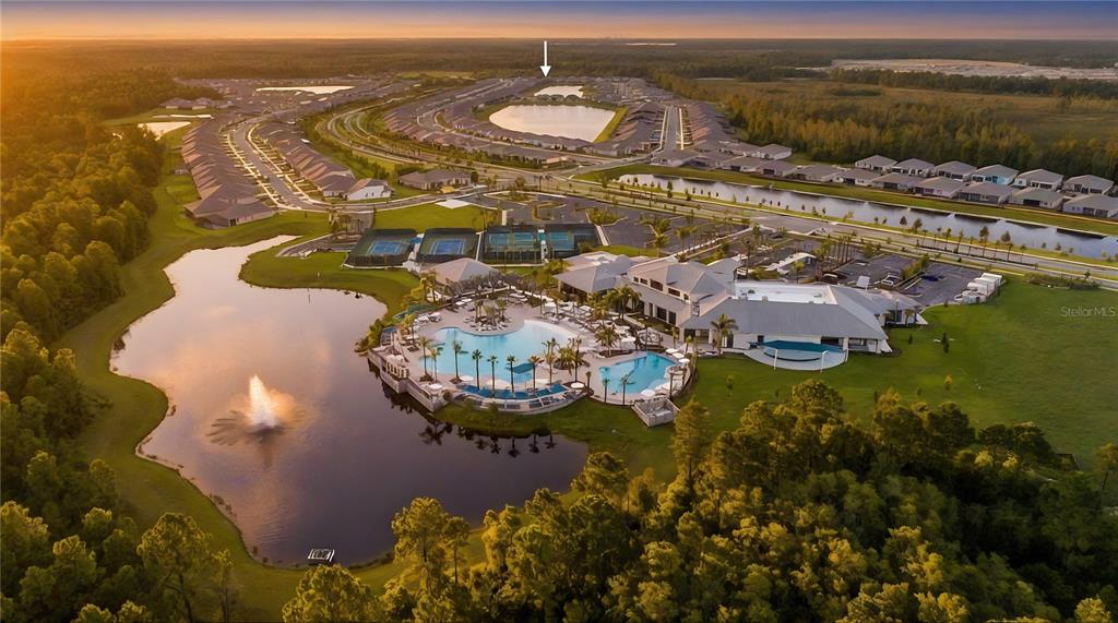 An aerial view shows a residential community with a large pool, clubhouse, and surrounding lakes — 2920 CHERRY BLOSSOM LOOP, ST CLOUD, FL