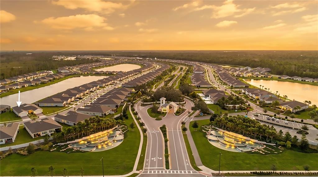 An aerial view shows a residential community with houses, lakes, and a gated entrance — 2920 CHERRY BLOSSOM LOOP, ST CLOUD, FL