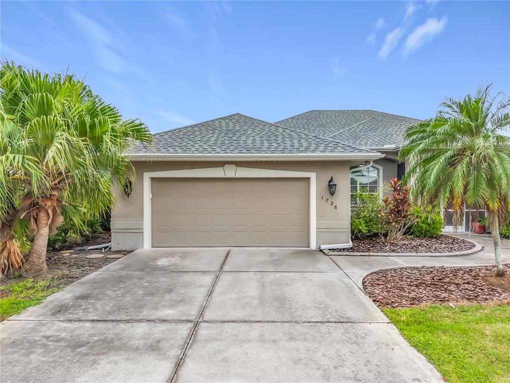 A single-story house exterior features a two-car garage, a concrete driveway, and two palm trees — 1736 NUREMBERG BOULEVARD, PUNTA GORDA, FL