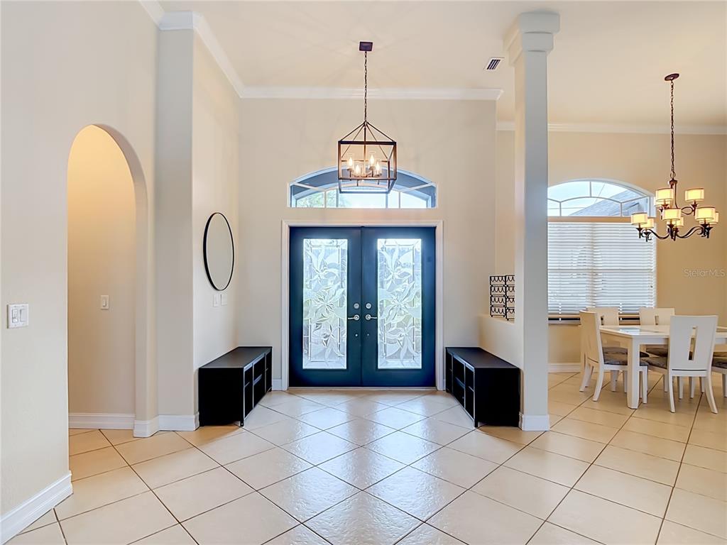 A tiled entryway features double front doors, a hanging lantern chandelier, and two black benches — 1736 NUREMBERG BOULEVARD, PUNTA GORDA, FL