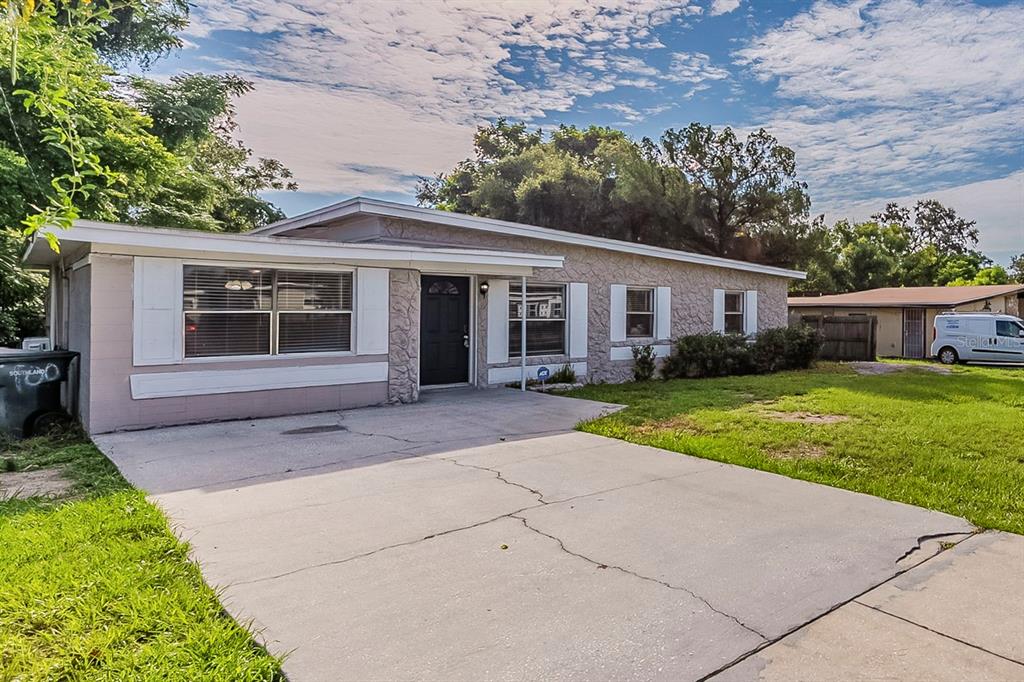 A single-story house with a stone facade, a concrete driveway, and a black front door — 1007 EMERALDA ROAD, ORLANDO, FL