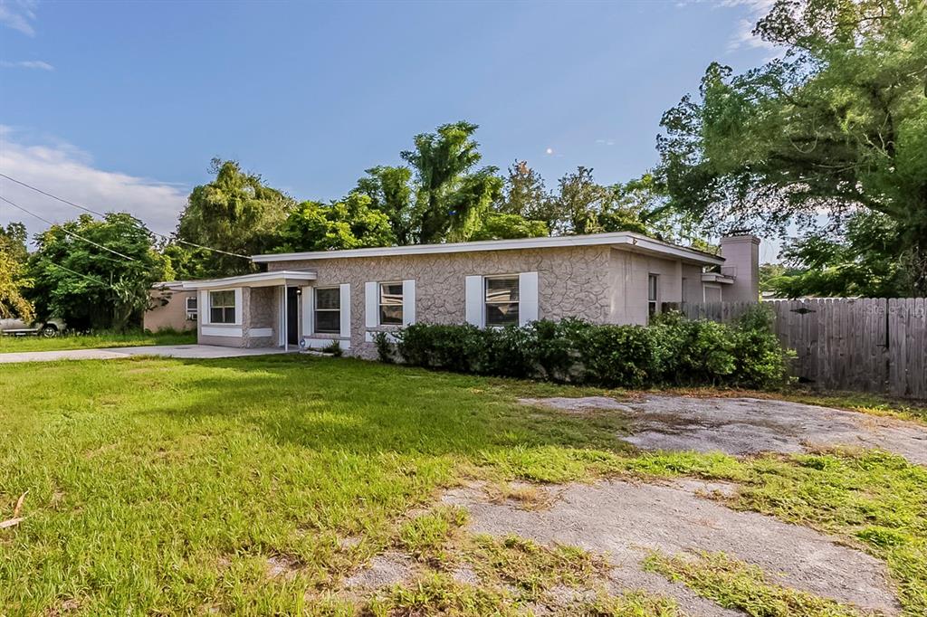 A single-story house with a textured stone facade, white trim, and a large front lawn — 1007 EMERALDA ROAD, ORLANDO, FL