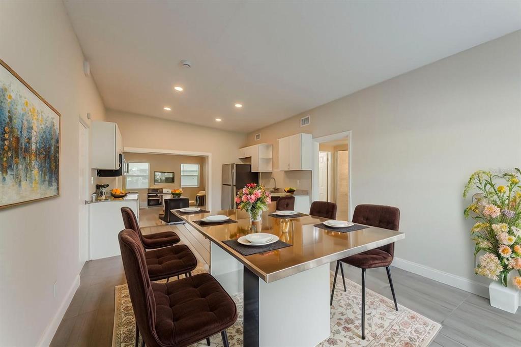 A dining area features a metallic table, brown upholstered chairs, and a floral arrangement — 1007 EMERALDA ROAD, ORLANDO, FL