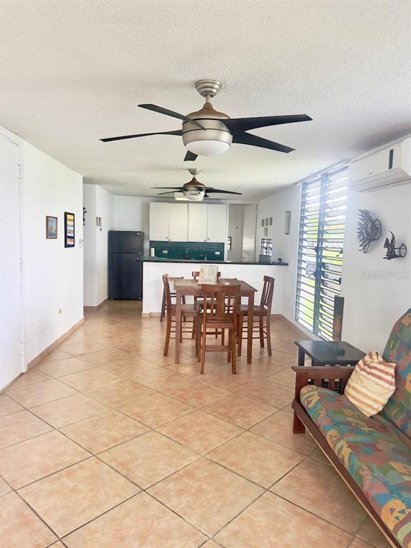 An open-concept room features a kitchen, dining area, and living space with tiled floors — Cond Villa. Marina 200 AVE. MARINA UNIT D-103, FAJARDO, PR