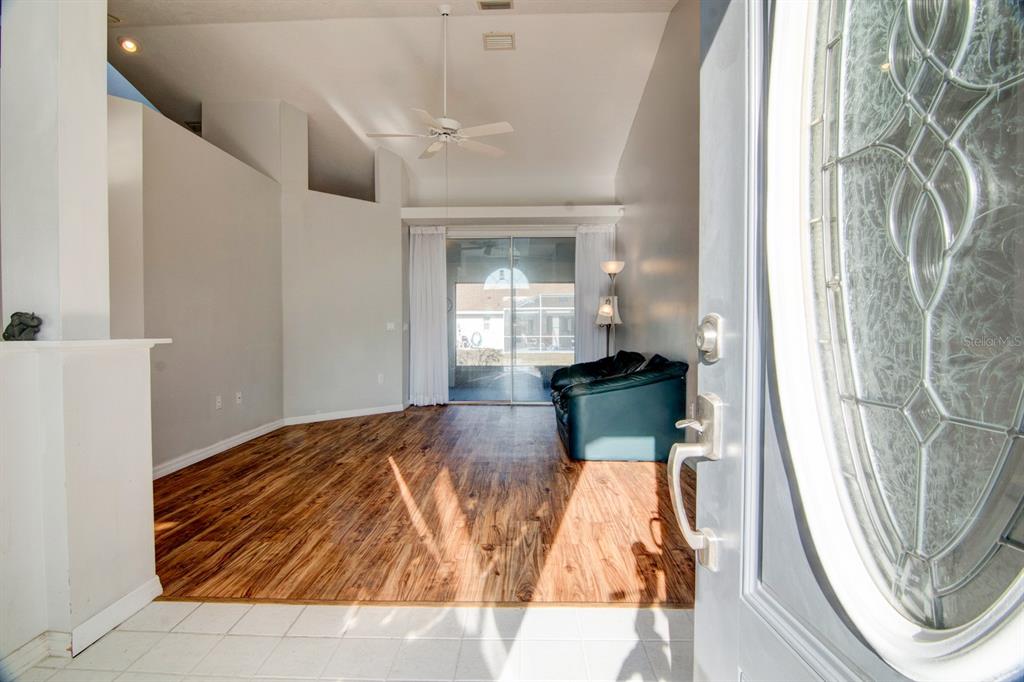 A view from an entryway into a living room with wood-look flooring and sliding doors — 119 W FOREST OAK PLACE, BEVERLY HILLS, FL