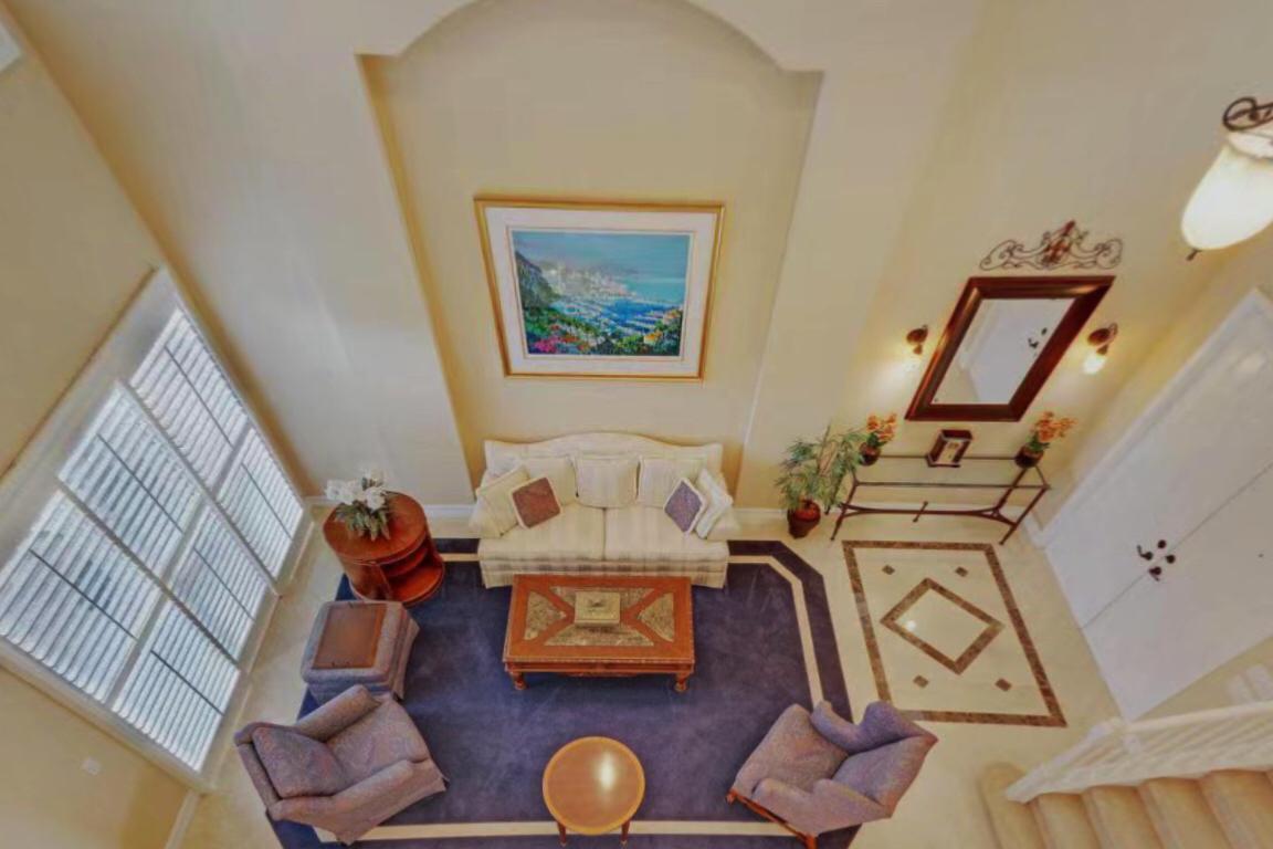 An elevated view of a living room featuring a blue rug, sofa, and armchairs — 8957 Sandy Crest Lane, Boynton Beach FL 33473, BOYNTON BEACH, FL
