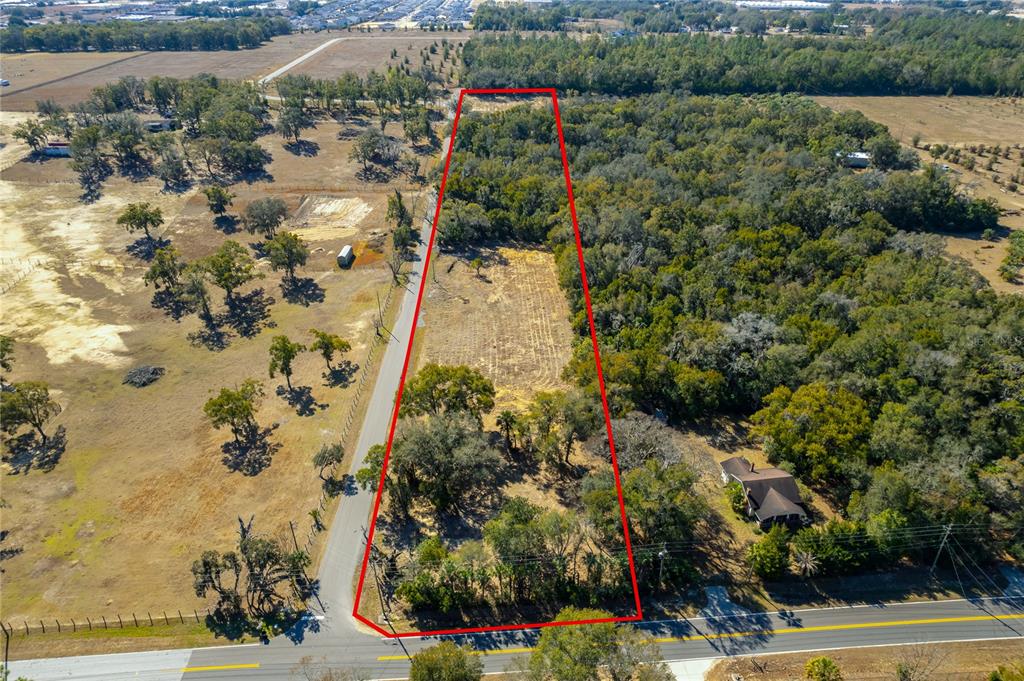 An aerial view shows a trapezoidal plot of land outlined in red along a road — 250 MCGUIRE RD, APOPKA, FL