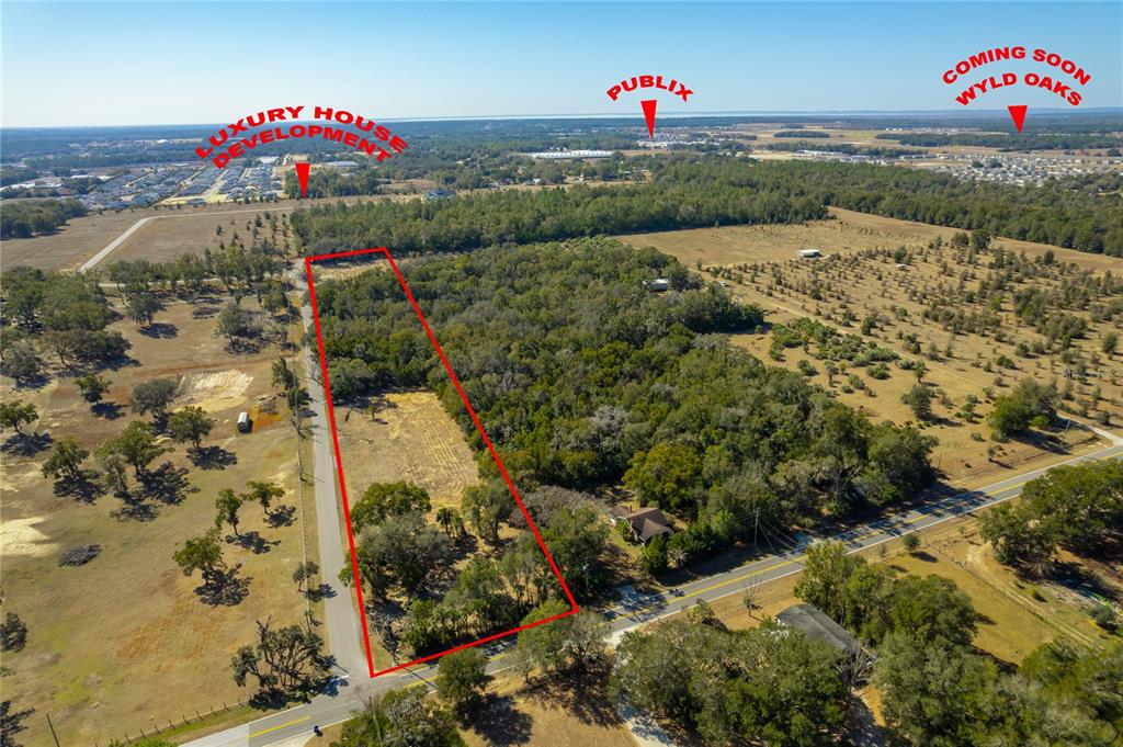An aerial view shows a rectangular plot of land outlined in red along a road — 250 MCGUIRE RD, APOPKA, FL