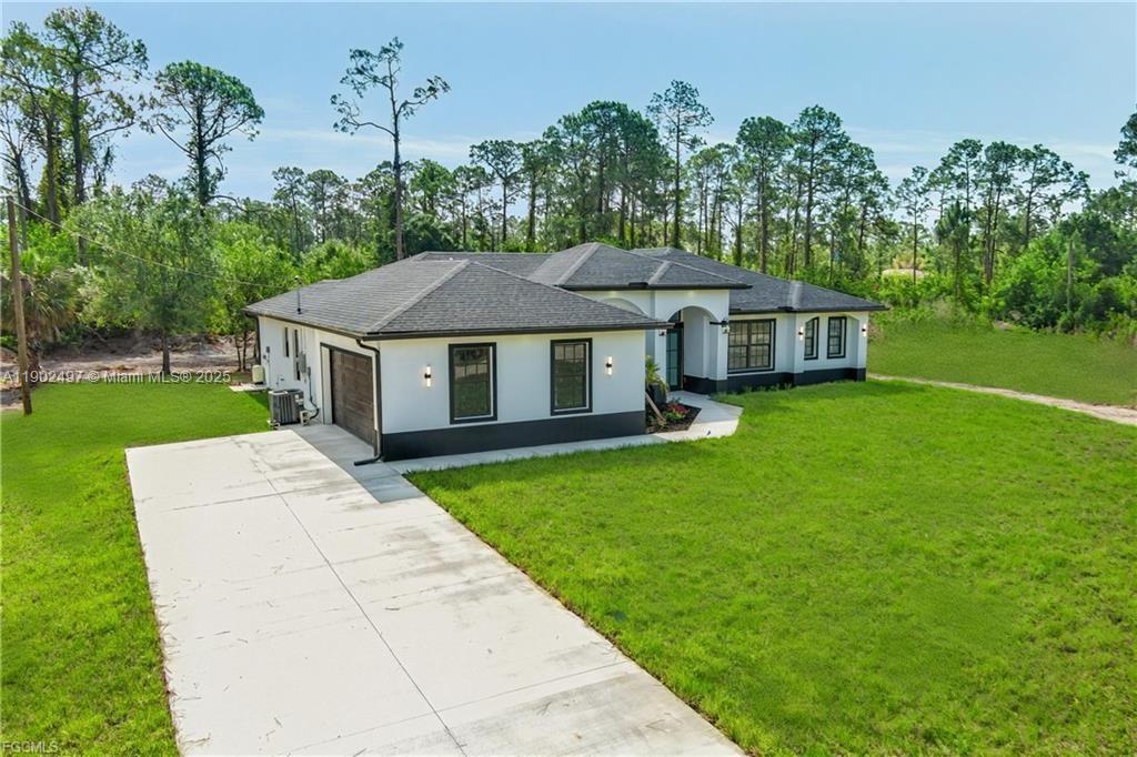 A single-story house with a white exterior, dark trim, and a concrete driveway — 1506 EIGHTH AVE, Lehigh Acres FL 33972, LEHIGH ACRES, FL