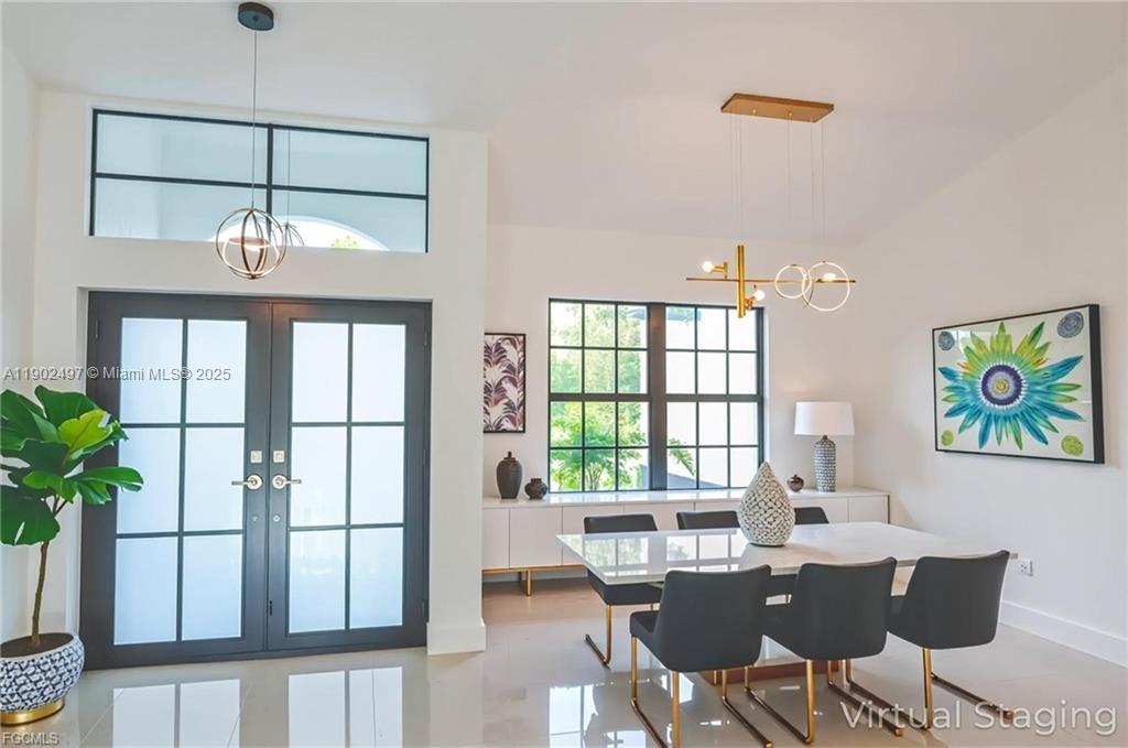 A dining room features a white table, black chairs, a modern chandelier, and double doors — 1506 EIGHTH AVE, Lehigh Acres FL 33972, LEHIGH ACRES, FL