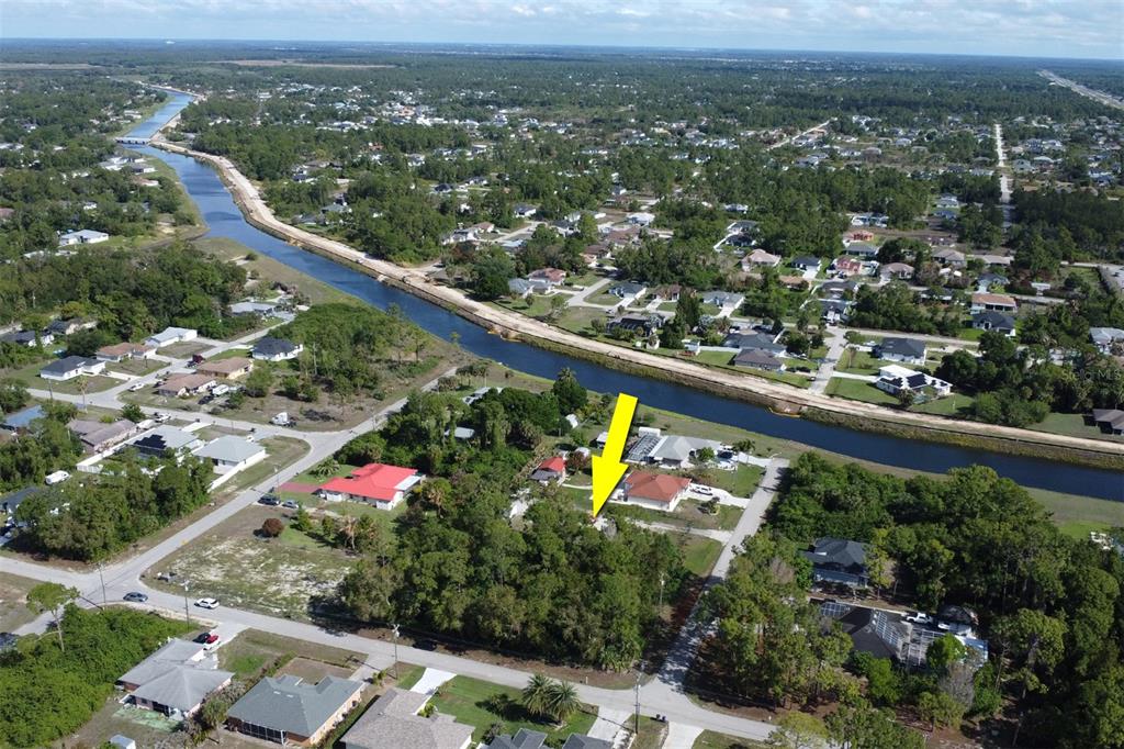 An aerial view shows a residential lot with a yellow arrow pointing toward a house — 1103 DOROTHY AVENUE N, LEHIGH ACRES, FL