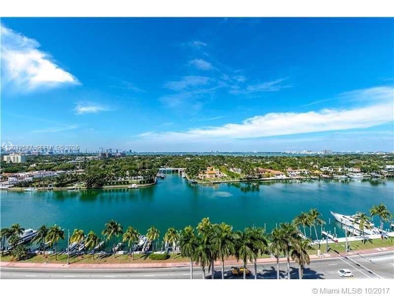 An aerial view shows a waterway lined with palm trees, boats, and residential properties — 5005 Collins Ave # 1202, Miami Beach FL 33140, MIAMI BEACH, FL