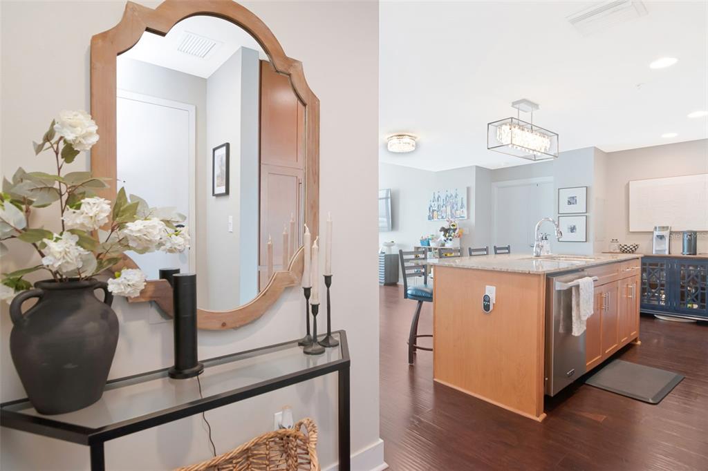 A foyer with a mirror and console table opens into a kitchen with an island — 1120 E KENNEDY BOULEVARD UNIT 1211, TAMPA, FL