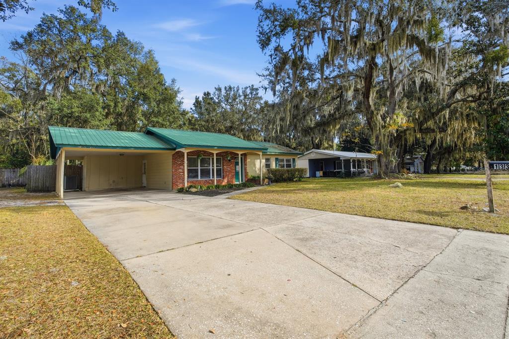 A single-story house with a green metal roof, brick facade, and an attached carport — 133 CRESTWOOD AVENUE, PALATKA, FL
