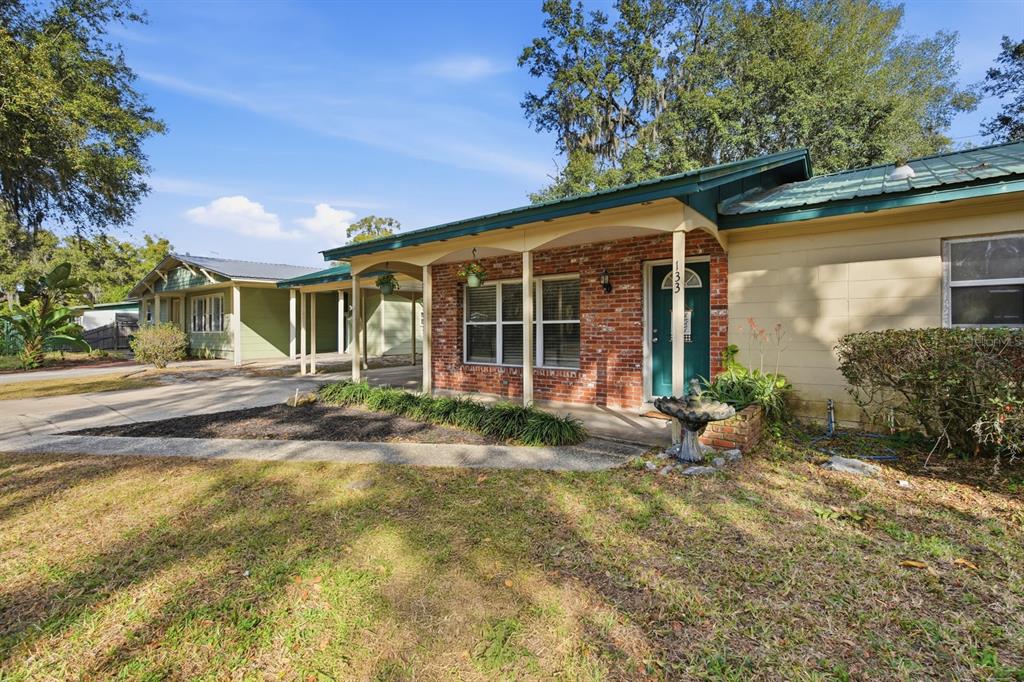 A single-story house with a brick facade, a covered porch, and a metal roof — 133 CRESTWOOD AVENUE, PALATKA, FL