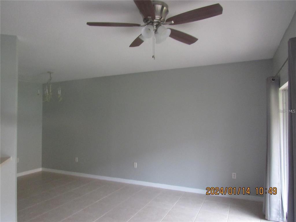 A living room features gray walls, tile flooring, a ceiling fan, and a sliding glass door — 244 CHELSEA DRIVE, DAVENPORT, FL