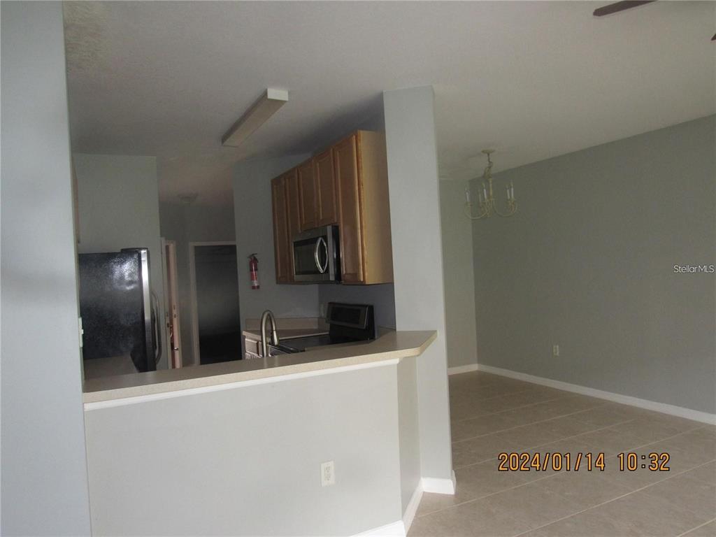 A kitchen with light wood cabinets and a breakfast bar overlooks a dining area — 244 CHELSEA DRIVE, DAVENPORT, FL