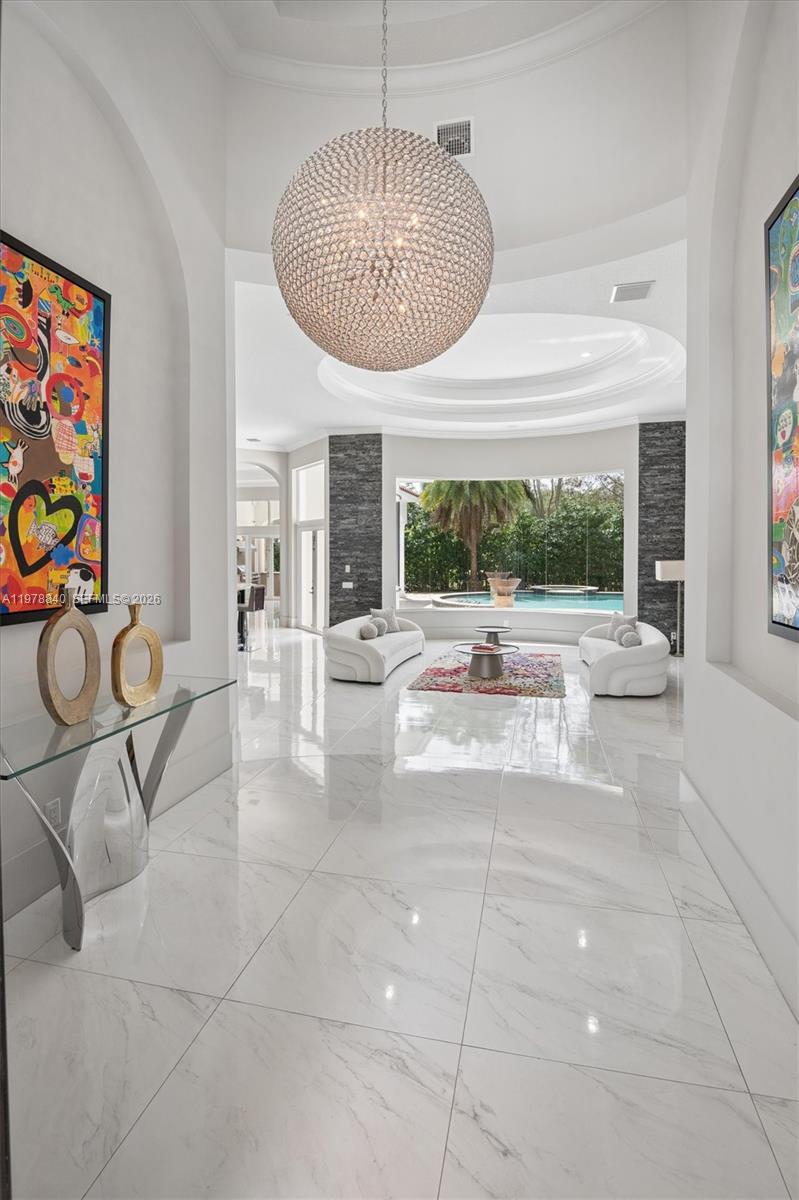 A bright, modern foyer with marble floors leads into a living area overlooking a pool — 12922 Grand Oaks Dr, Davie FL 33330, DAVIE, FL
