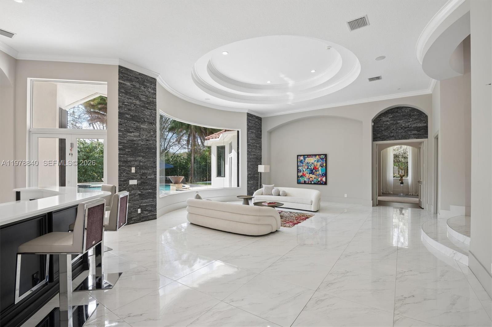 A spacious living room features white marble floors, a circular tray ceiling, and stone accents — 12922 Grand Oaks Dr, Davie FL 33330, DAVIE, FL