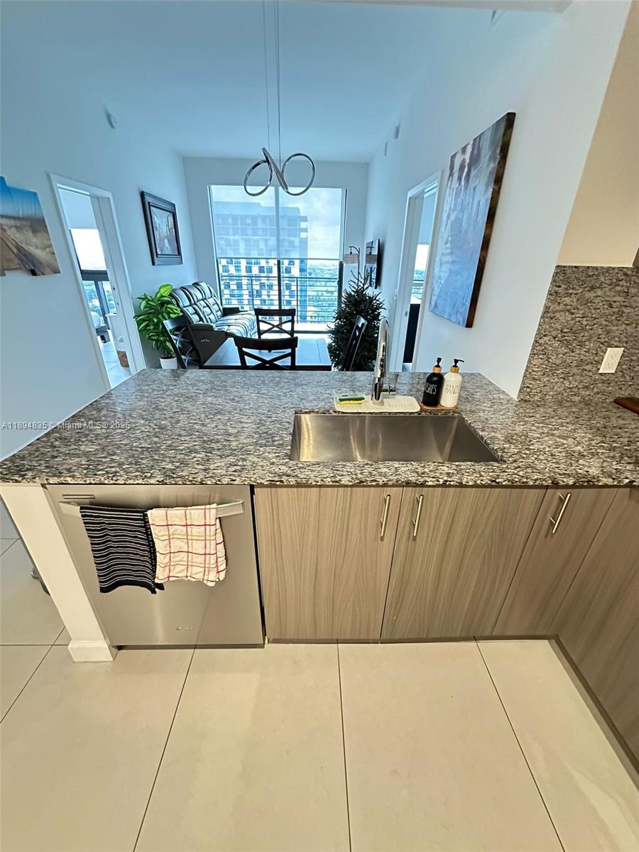 A kitchen with granite countertops and stainless steel appliances overlooks a dining and living area — 5350 NW 84th Ave # 1818, Doral FL 33166, DORAL, FL