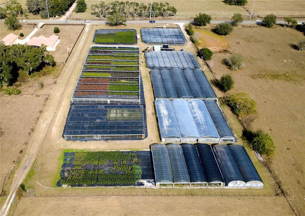 An aerial view shows a plant nursery with multiple greenhouses and outdoor growing beds — 23010 WOLF BRANCH ROAD, SORRENTO, FL