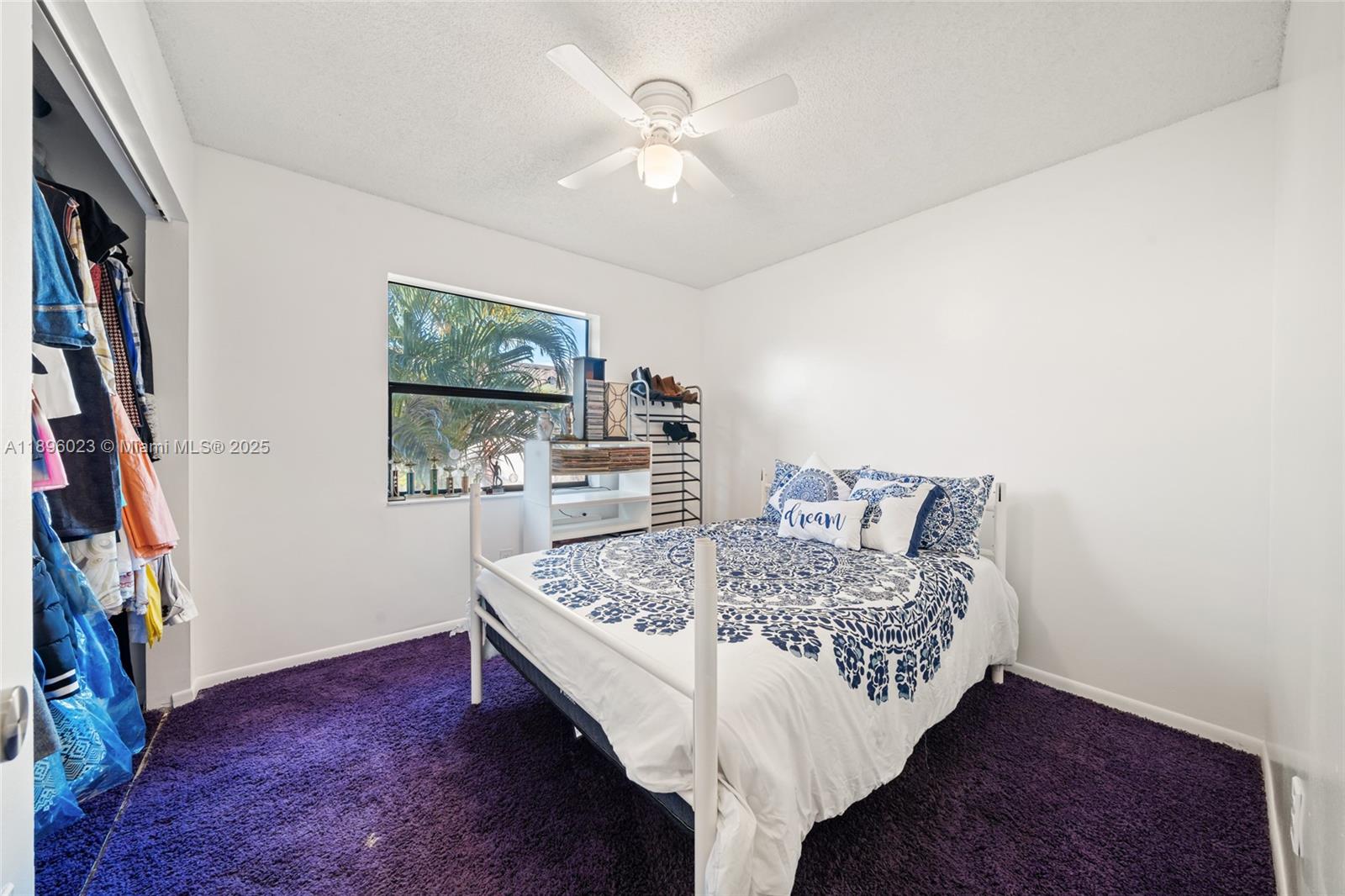 A bedroom features a white bed, purple carpet, a ceiling fan, and a closet — 861 NE 207th Ln # 14, Miami FL 33179, MIAMI, FL