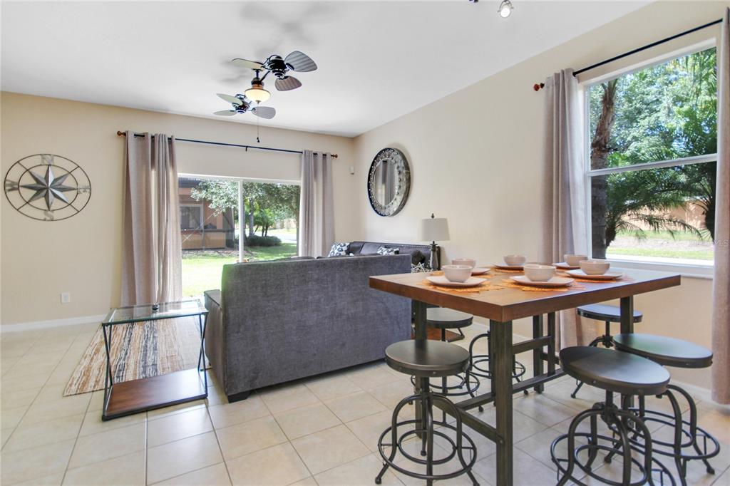 A living and dining area features tile flooring, a ceiling fan, and sliding glass doors — 2740 COUPE STREET, KISSIMMEE, FL