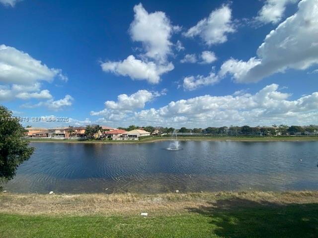 A view of a lake with a fountain and houses in the background — 11001 NW 83rd St # 204, Doral FL 33178, DORAL, FL